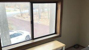 A room with a window, a bench, and a bed.