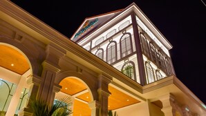 A multi-story building with a prominent sign at the top. - Peranakan House (Wichit)