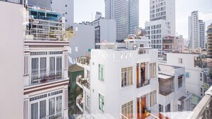 A multi-story building with balconies, large windows, and a rooftop terrace. - Moschino HT (Nha Trang)
