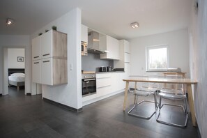 Kjøleskap, mikrobølgeovn, oppvaskmaskin og høy barnestol