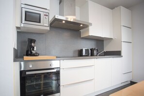 Kjøleskap, mikrobølgeovn, oppvaskmaskin og høy barnestol