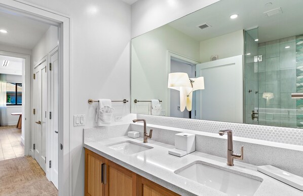 Un bagno moderno con un grande specchio, due lavabi e una doccia.