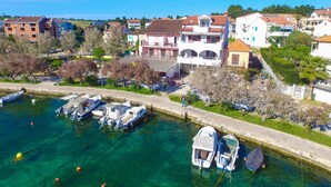 Un port de plaisance où sont amarrés plusieurs bateaux, entouré d’immeubles résidentiels à l’architecture variée.