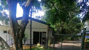 A garden with a pathway, a tree, and a fence. - Signature Kandy (Kandy)