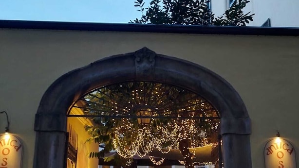 An archway entrance to a restaurant with a menu board on either side. - The Tuscanian Hotel (Lucca)