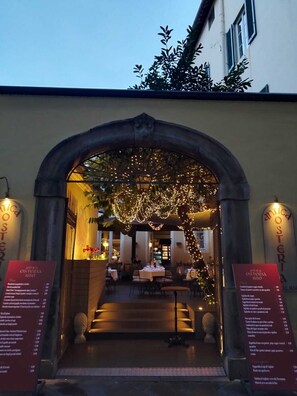 An archway entrance to a restaurant with a menu board on either side. - The Tuscanian Hotel (Lucca)