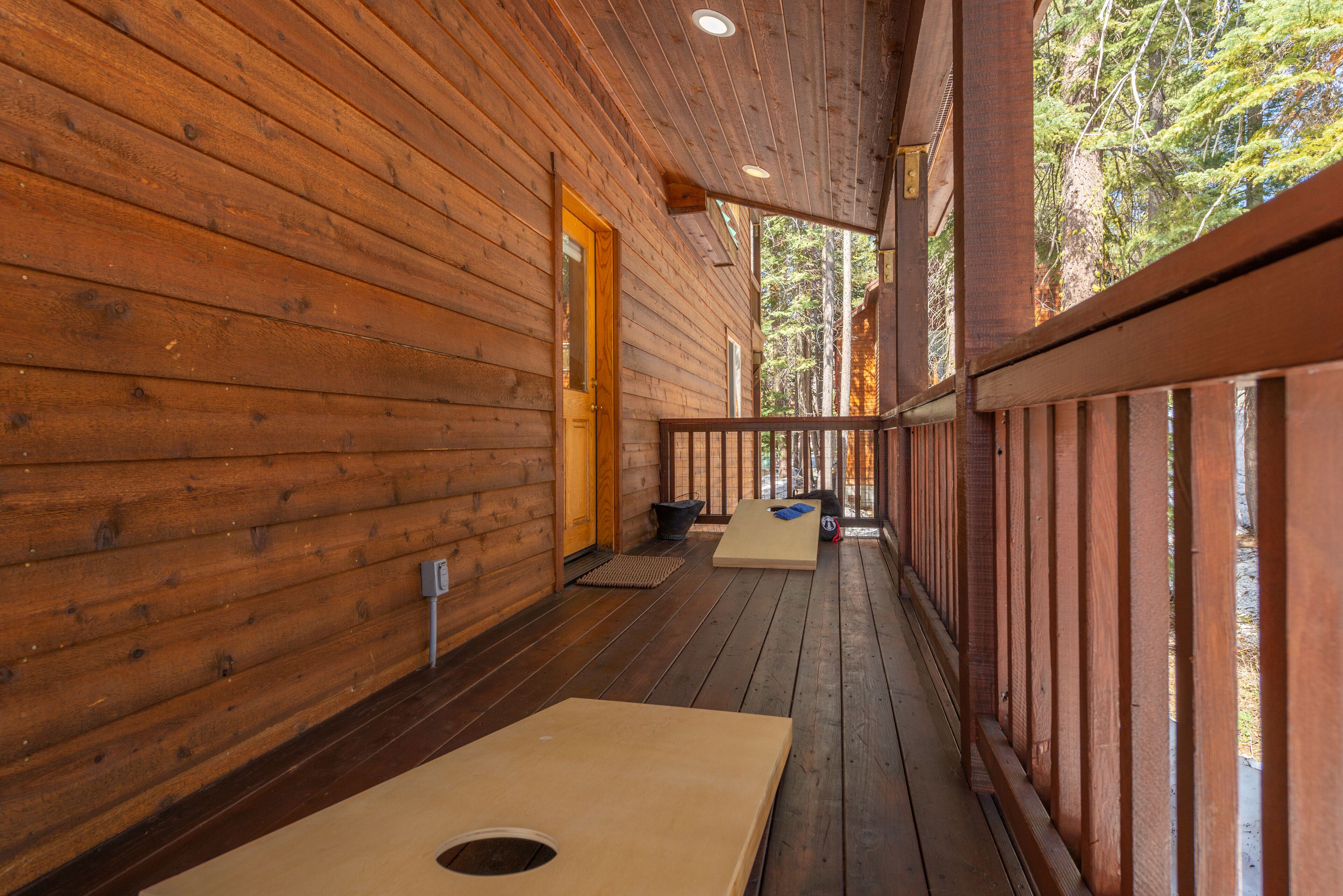 Une cabane en bois avec une véranda, une porte et une fenêtre.
