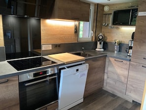 Eine kleine Küche mit Geschirrspüler, Backofen und Mikrowelle.