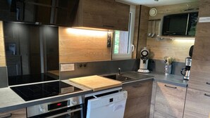 Una cocina compacta con lavavajillas, horno y microondas.