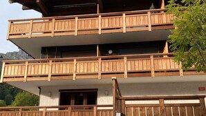 Un edificio de varios pisos con balcones de madera y una puerta de garaje.