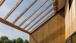 Il s’agit d’une structure en bois dotée d’un toit incliné, qui fait probablement partie de l’extérieur d’un bâtiment.