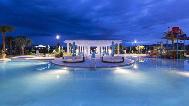 A swimming pool with a covered seating area and a children's play structure. - Westside Charm | Games Room | Kids Bedrooms (Kissimmee)