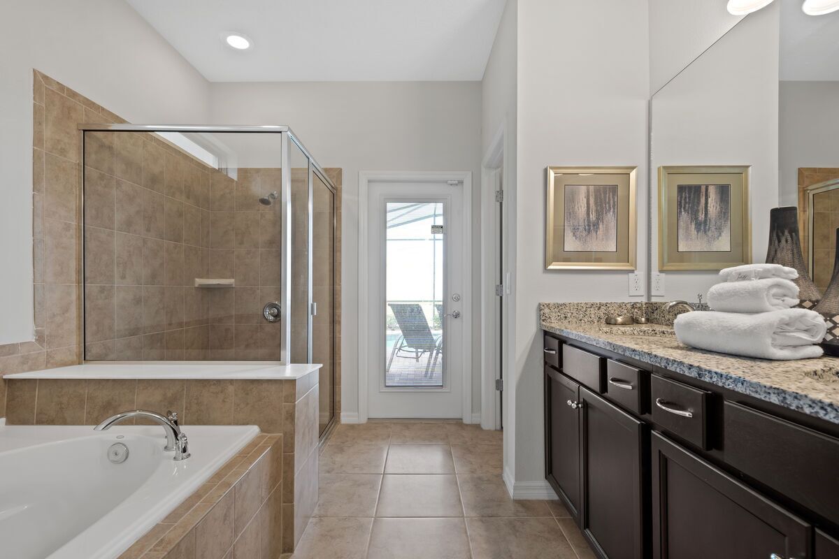 A modern bathroom with a glass-enclosed shower, a freestanding bathtub, and a vanity with a countertop.