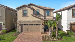 A two-story house with a garage, stone facade, and a well-maintained lawn. - Westside Charm | Games Room | Kids Bedrooms (Kissimmee)