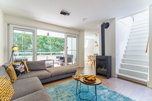 A modern living room with a sofa, a coffee table, and a fireplace.