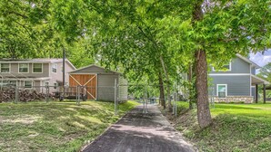 A residential area with a paved driveway leading to a house with a wooden garage door.