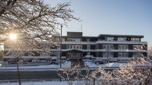 A multi-story building with a modern architectural design, featuring a flat roof and large windows. - Apartement - Am Waltenberg 70-R | Winterberg (Winterberg)