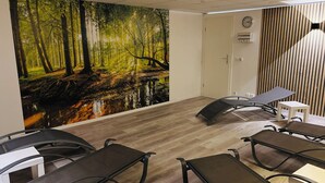 A conference room with a forest mural, a clock, and modern furniture. - Apartement - Am Waltenberg 70-R | Winterberg (Winterberg)