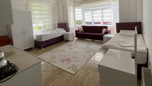 A bedroom with a bed, a sofa, a desk, and a wardrobe. - Kapadokya Deluxe Apart (Ürgüp)