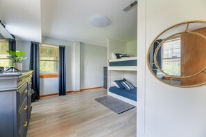 A compact room with a bunk bed, a small desk, a radiator, and a mirror. - Wildest Dream - S Nags Head MP 17, Oceanfront, Direct Ocean Access, Air Hockey, Pets OK (South Nags Head)