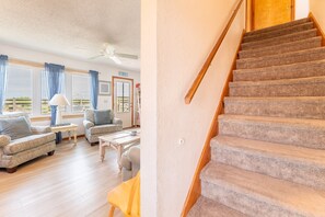 Una escalera con peldaños alfombrados y barandillas de madera, que conduce a un piso superior.
