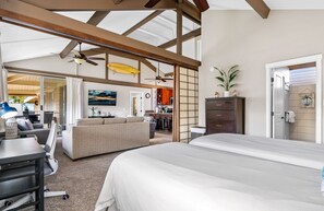 Een ruime kamer met een groot bed, een bureau, een zithoek en een eethoek.