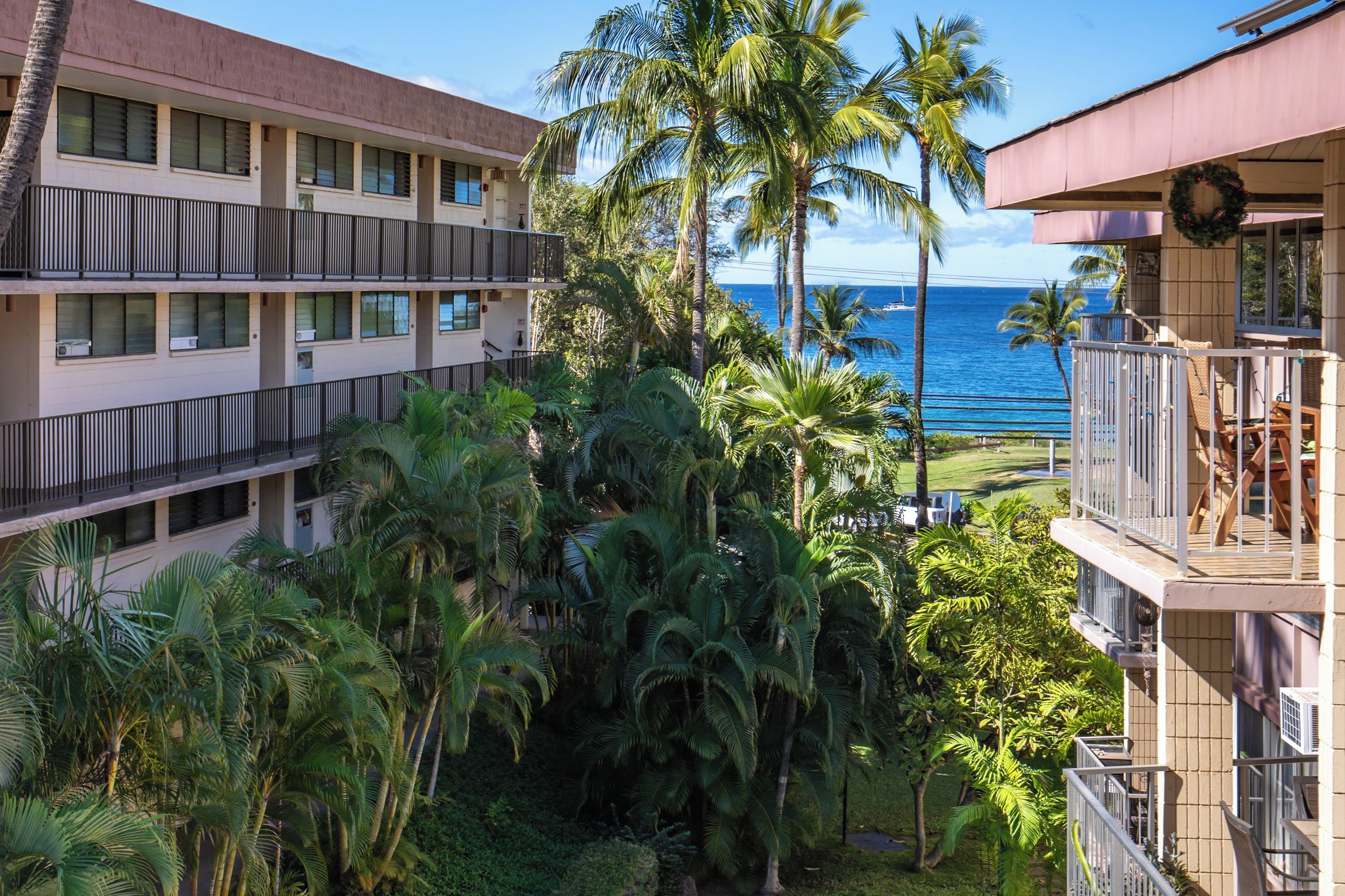 A hotel with multiple balconies overlooking a beach and ocean.