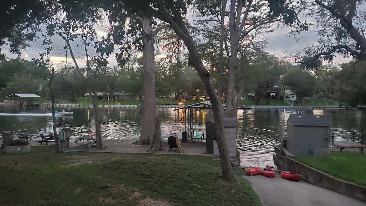 Un parc au bord du lac, doté d’un kiosque, de tables de pique-nique et de kayaks rouges.