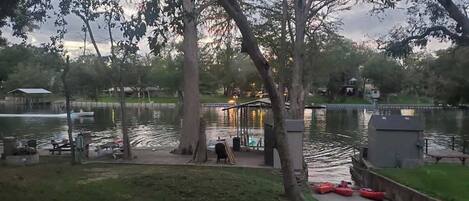 Un parc au bord du lac, doté d’un kiosque, de tables de pique-nique et de kayaks rouges.
