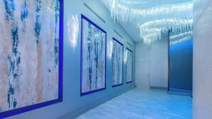A hallway with large abstract paintings on the walls, a tiled floor, and a ceiling with icicle-like decorations. - DOWNTOWN 2BR Walk to Superdome,Parade French Quarter (New Orleans)