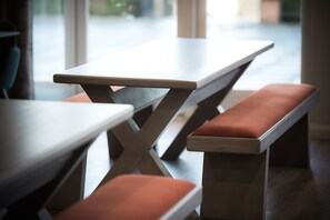 A modern dining area with wooden tables and benches. - The Tytherington (Macclesfield)