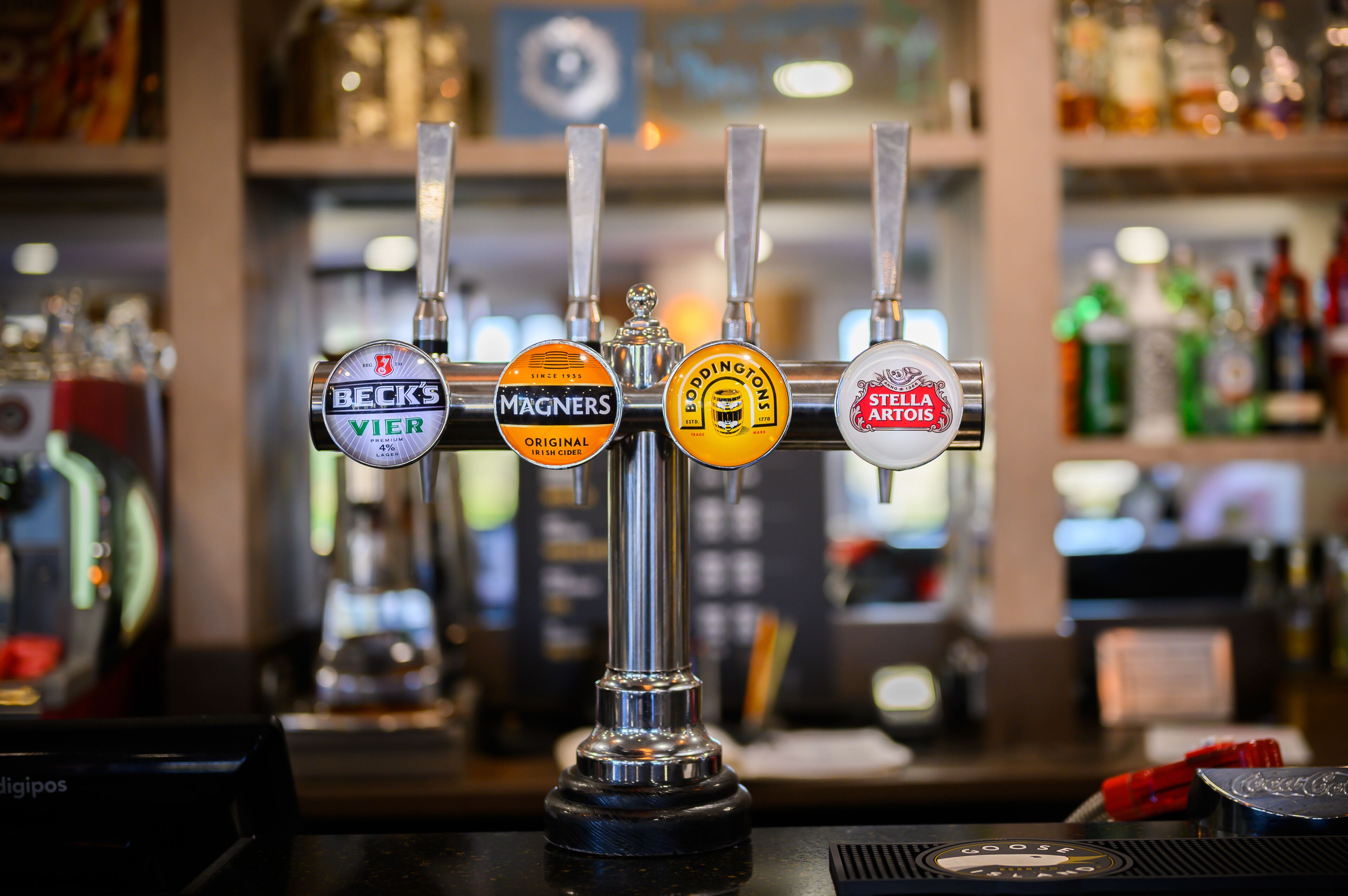 Un bar doté de quatre tireuses à bière, chacune affichant une marque différente.