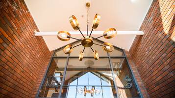 A modern interior with a unique ceiling design and brick walls.