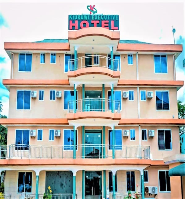 A multi-story hotel with balconies and air conditioning units.