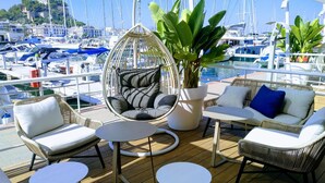 A deck with wicker furniture, a hanging chair, and a potted plant. - House - Sleeps 4 - Pool (Denia)