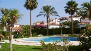 A pool surrounded by palm trees and a well-maintained garden. - House - Sleeps 4 - Pool (Denia)
