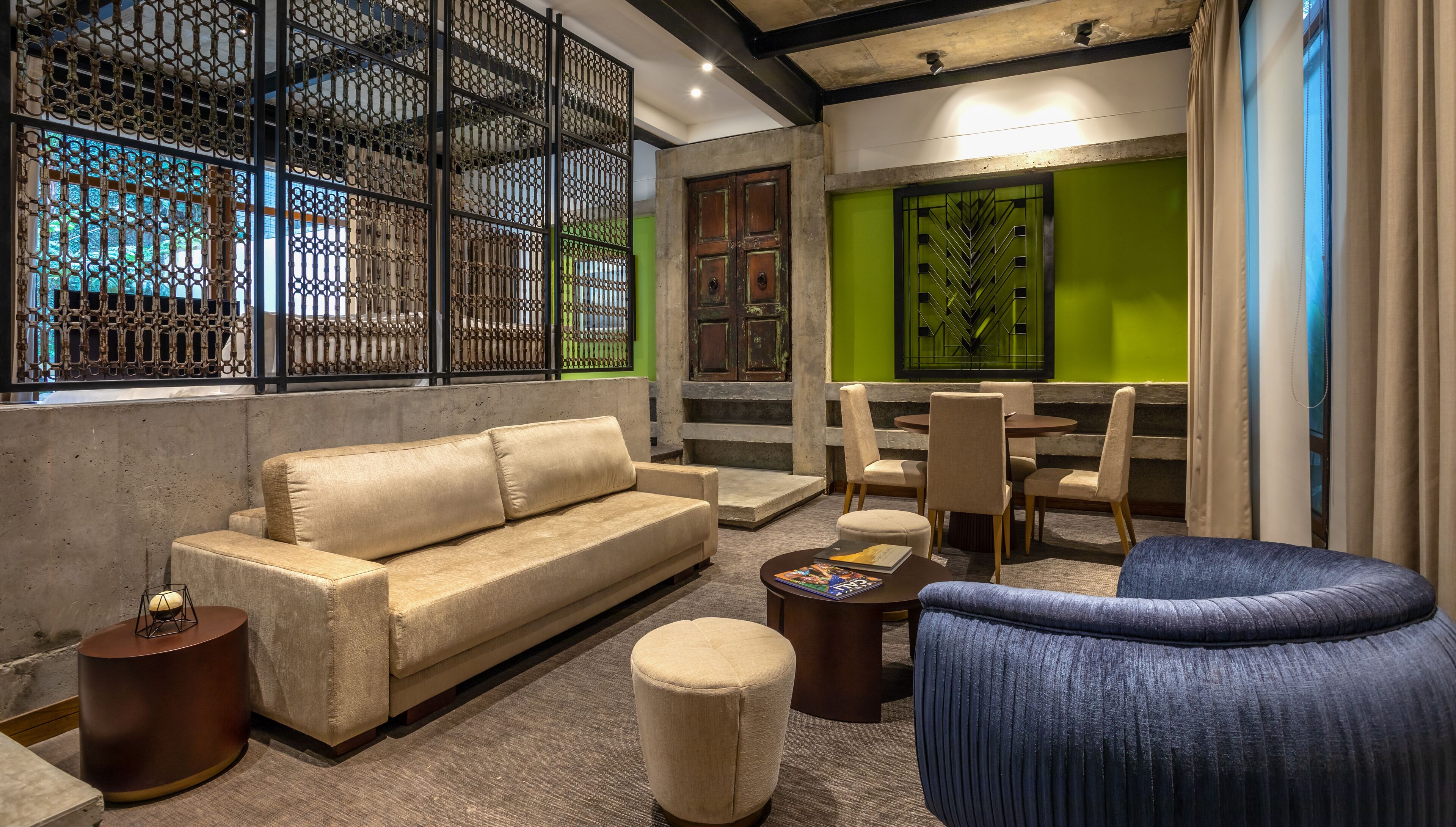 A modern lounge area with a sofa, chairs, a coffee table, and a decorative screen.