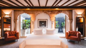 A spacious bedroom with a large bed, two armchairs, and a framed picture on the wall. - Alko Hotel Casa Nispero (Cali)