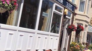 A building with a sign reading "Macleods Guest House" and a smaller sign below stating "All Rooms En-Suite." - Macleods Guest House (Blackpool)