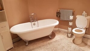 A bathroom with a clawfoot bathtub, a toilet, and a sink. - Macleods Guest House (Blackpool)