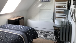 Een moderne badkamer met dakraam, douche en wastafel.