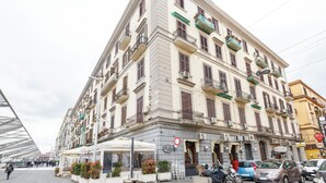 A multi-story hotel with balconies, a terrace, and a sign indicating it is a hotel.