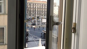 A view through a window of a city street with a building labeled "KIMBO" in the background.