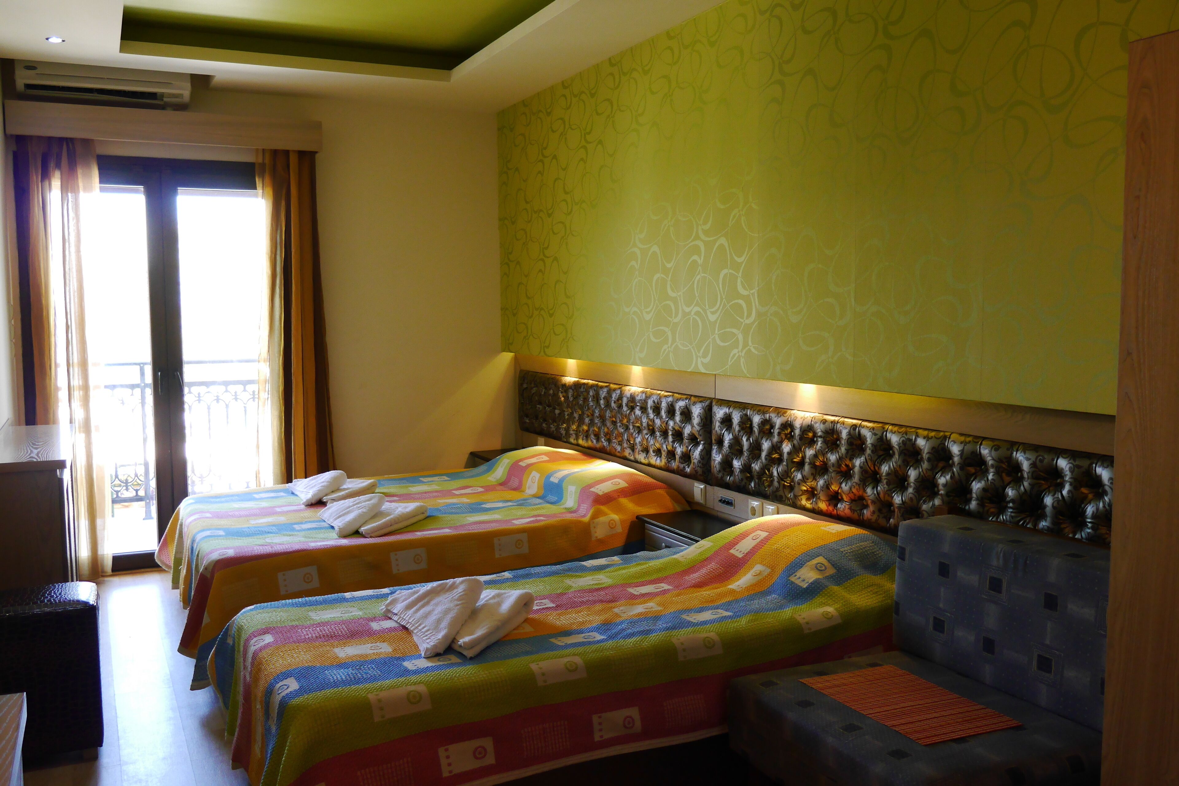A hotel room with two beds, a sofa, and a desk.