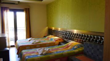 A hotel room with two beds, a sofa, and a desk.