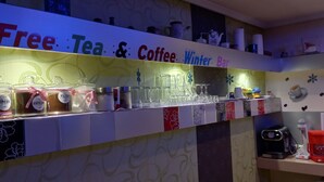 Un'area bar con un cartello che dice 'Free Tea & Coffee Winter Bar'.