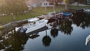 Un bateau était amarré dans une marina, avec une maison visible au loin.