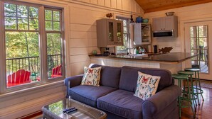 Un interior acogedor de cabaña con sala de estar, cocina y comedor.