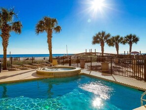 A clear blue pool with a hot tub, surrounded by palm trees and a wooden deck. - Great rates!! PENTHOUSE BEACHFRONT!  Most Stunning View of Gulf Shores!!   (Gulf Shores)