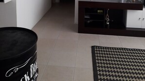 Un soggiorno con televisore a parete, una bicicletta, un quadro incorniciato e un mobile porta TV in legno scuro.